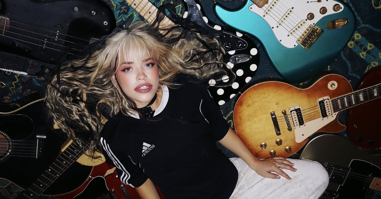 Shelby Carter surrounded by electric and acoustic guitars