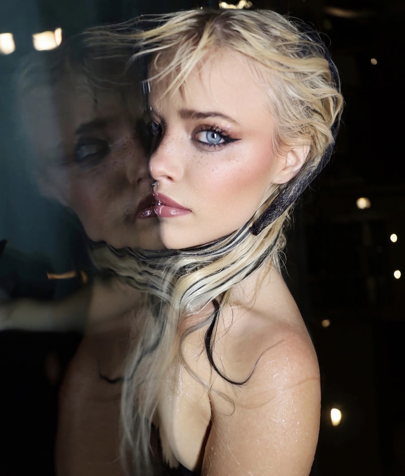 Close portrait of Shelby Carter beside her reflection
